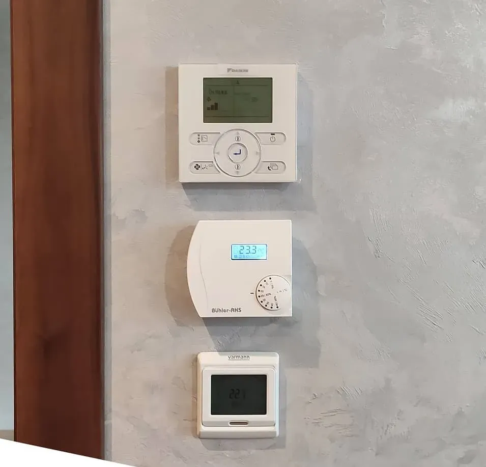 Three separate controllers on the wall for AC, humidification and heating